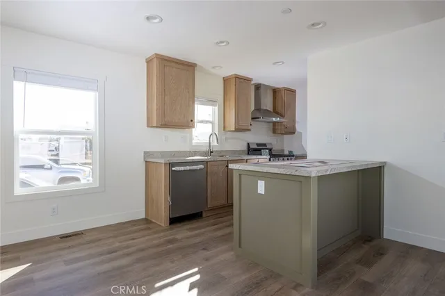 a kitchen with a sink cabinets stainless steel appliances and a window