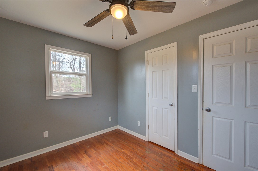 325 Rock Quarry Road Travelers Rest, SC 29690 - Photo 17 of 37 This cozy bedroom features warm hardwood flooring, a bright window, and practical ceiling fan.