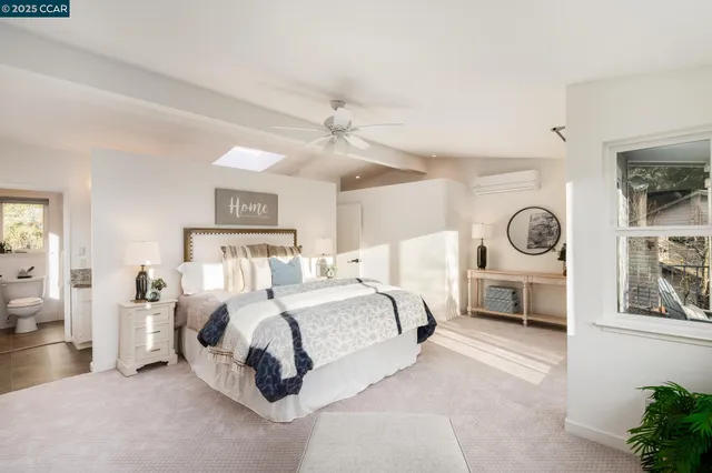 a spacious bedroom with a bed a mirror and a large window with the outer view