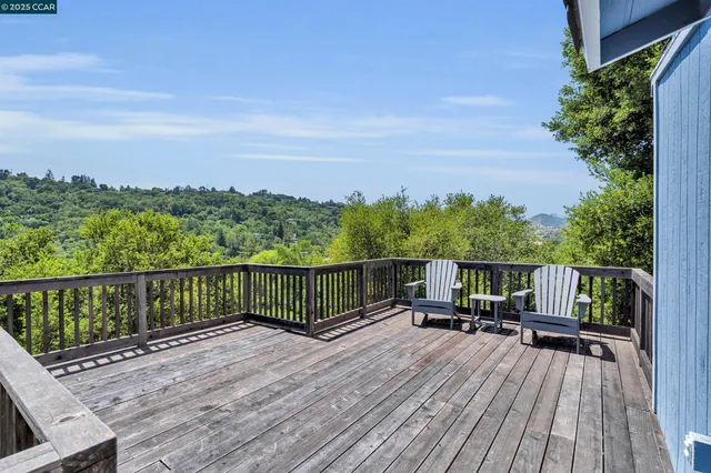 a view of a balcony with two chairs and wooden floor