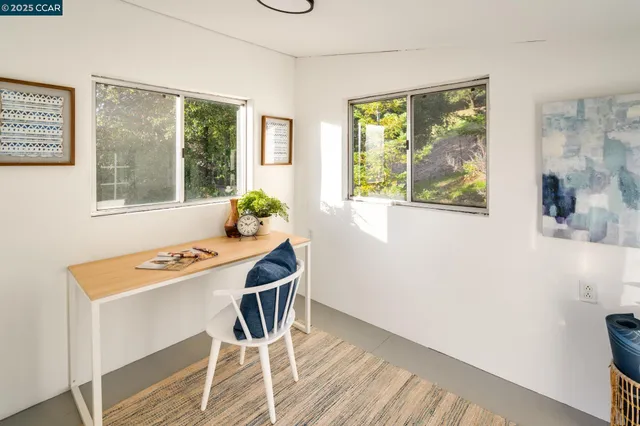 a view of a workspace with furniture and a window