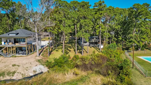 a view of swimming pool with lawn chairs and plants