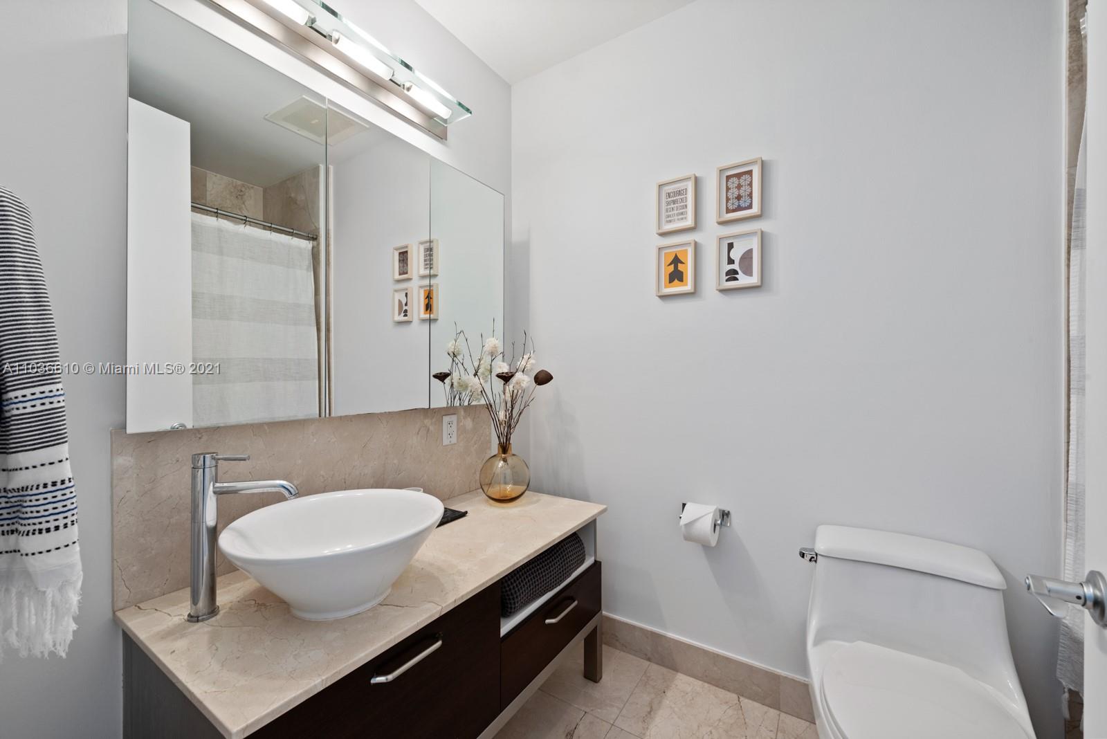 218 Southeast 14th Street, Unit TS103 Miami, FL 33131 - Photo 15 of 31 a bathroom with a sink a toilet and a mirror