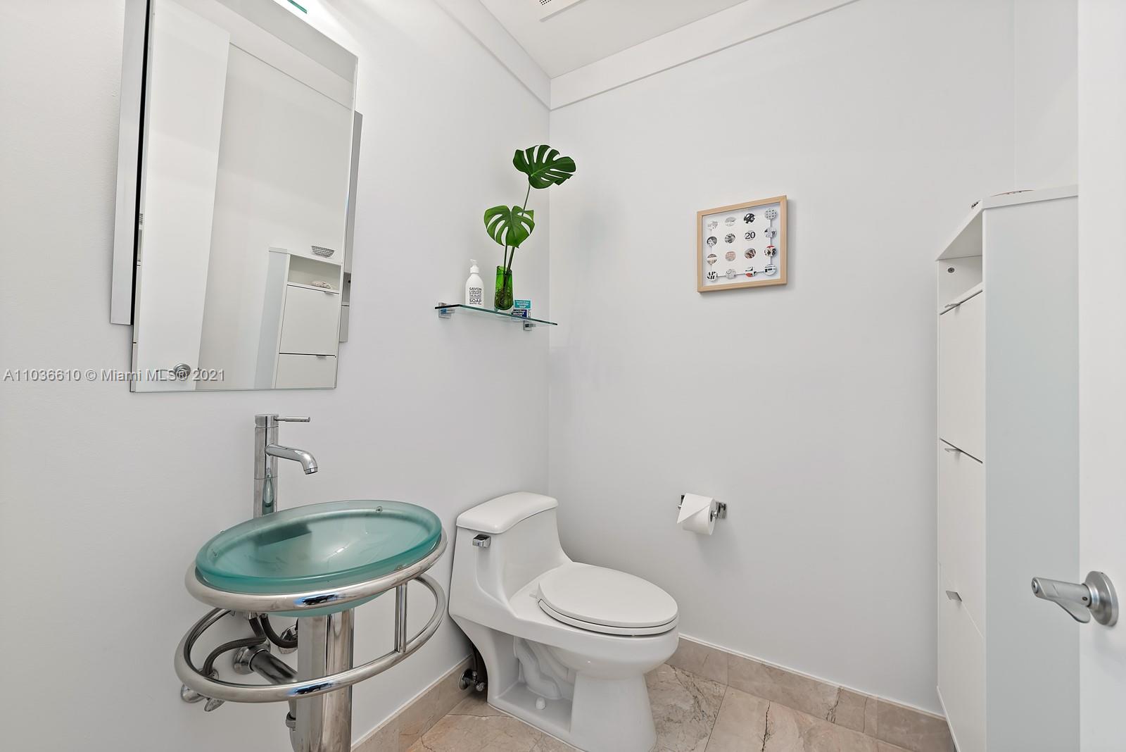 218 Southeast 14th Street, Unit TS103 Miami, FL 33131 - Photo 16 of 31 a bathroom with a toilet a sink and a mirror