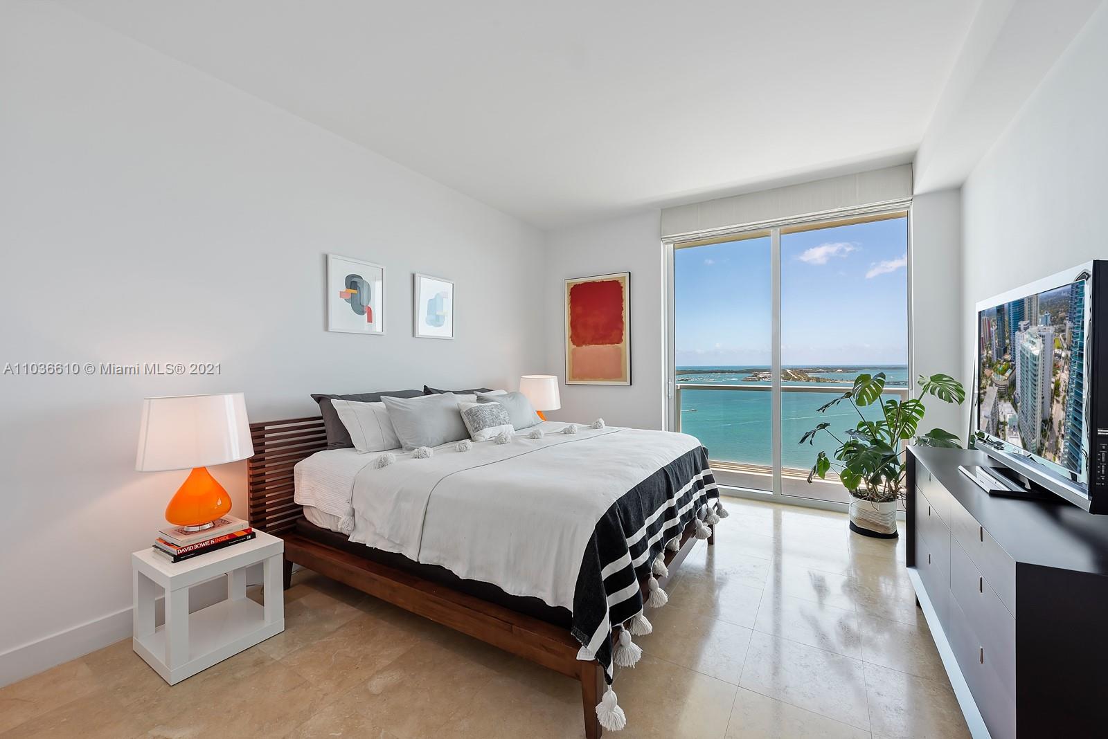218 Southeast 14th Street, Unit TS103 Miami, FL 33131 - Photo 7 of 31 a bedroom with a bed and a flat screen tv