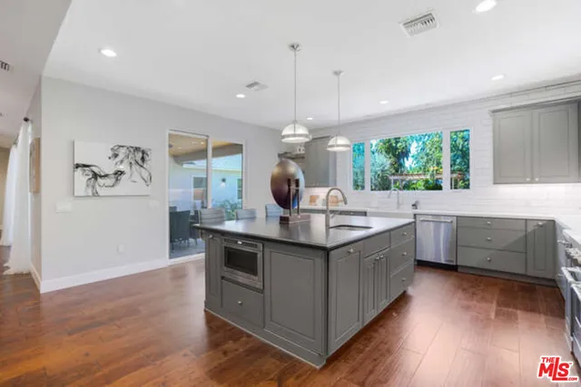 a kitchen with kitchen island a sink stove and wooden floor