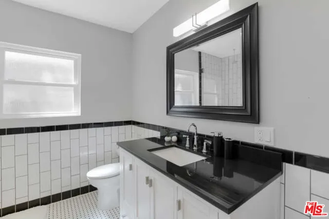 a bathroom with a sink a toilet and a mirror