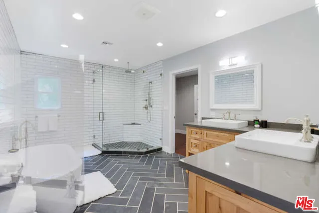 a spacious bathroom with a double vanity sink a mirror and a bathtub