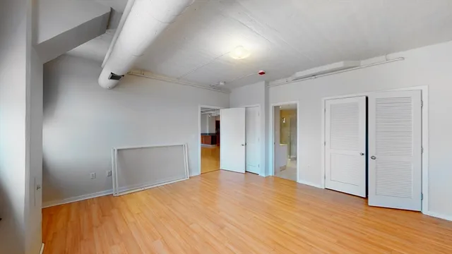 an empty room with wooden floor and closet