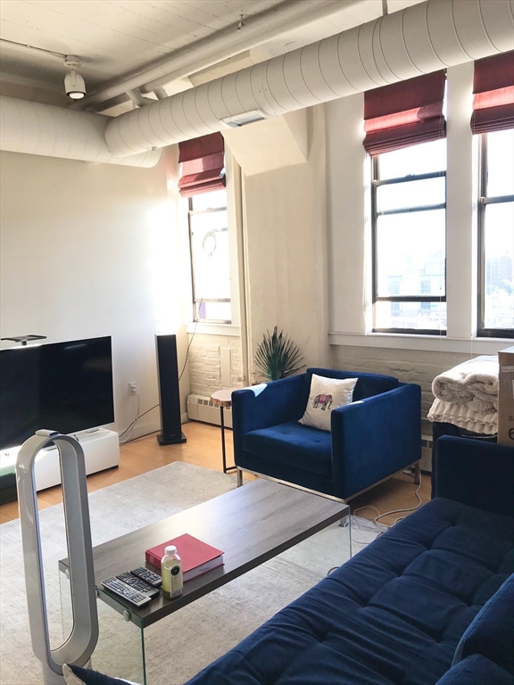 210 South Street, Unit 104 Boston, MA 02111 - Photo 2 of 24 a living room with furniture and a window
