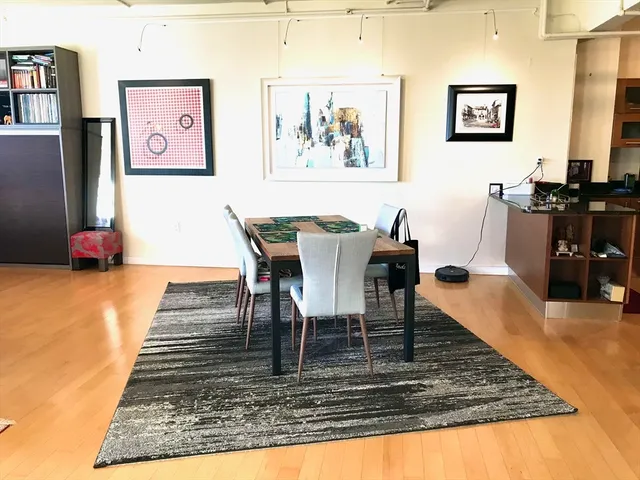 a view of a dining room with furniture a rug and wooden floor