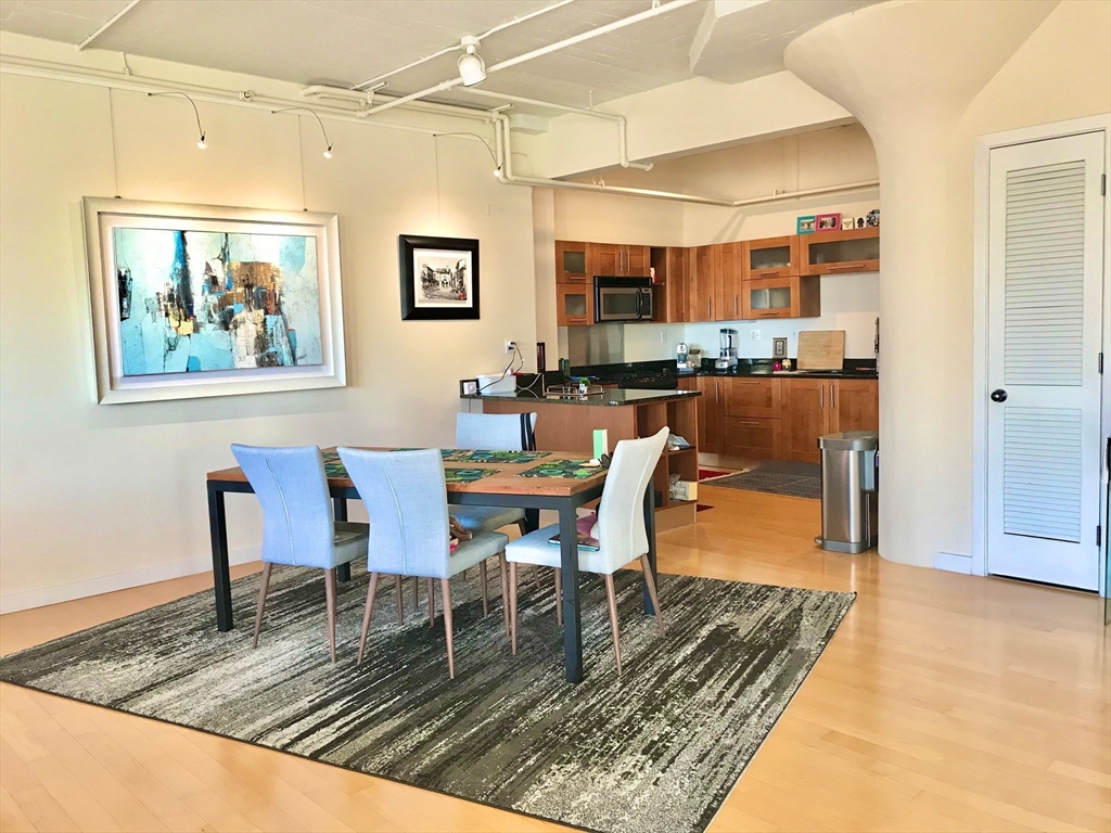 210 South Street, Unit 104 Boston, MA 02111 - Photo 4 of 24 a dining room with wooden floor and a table