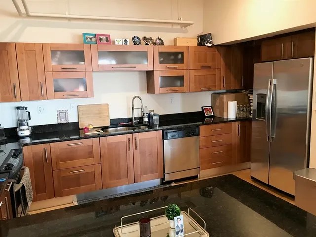 a kitchen with stainless steel appliances granite countertop a refrigerator and a sink