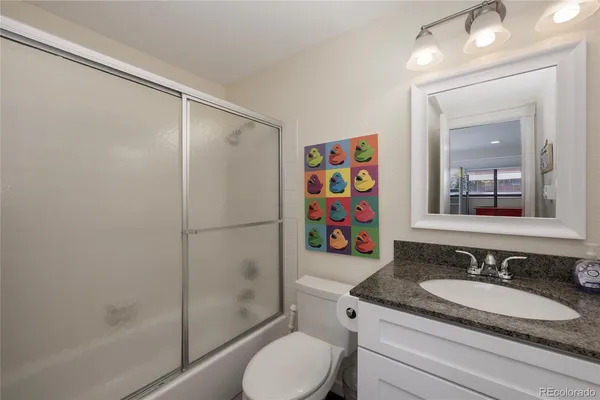 a bathroom with a granite countertop sink toilet and shower