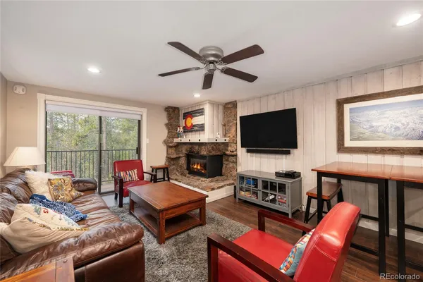 a living room with furniture a flat screen tv and a fireplace