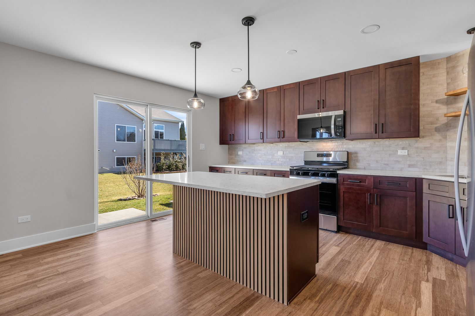 25653 Bridle Path Channahon, IL 60410 - Photo 3 of 43 a kitchen with kitchen island granite countertop wooden cabinets a sink dishwasher and a stove with wooden floor