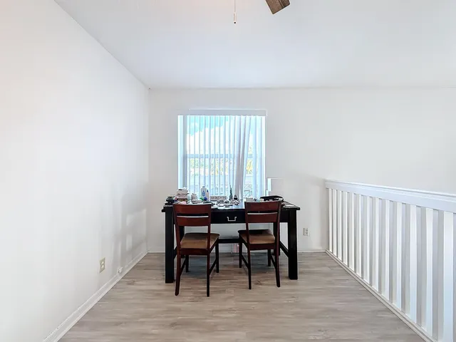 a view of empty room with wooden floor and furniture