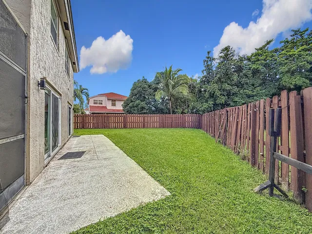 a view of a chair and table in backyard of the house