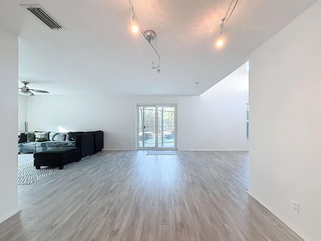 a living room with furniture flat screen tv and a large window