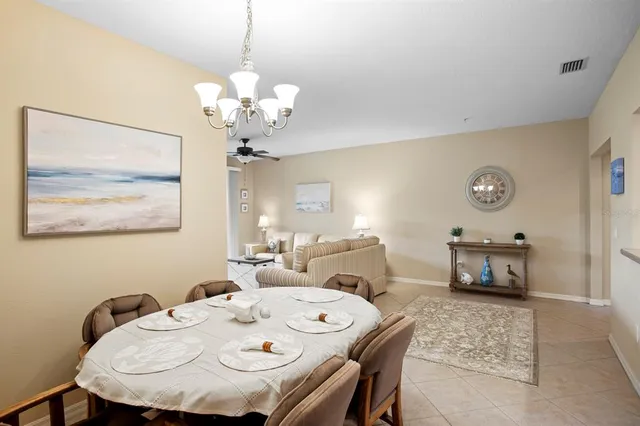 a dining room with wooden floor a chandelier a wooden table and chairs