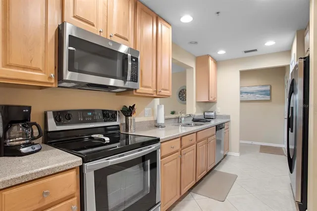 a kitchen with stainless steel appliances a stove a microwave a sink and cabinets
