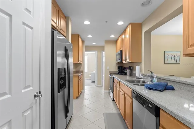 a kitchen with stainless steel appliances granite countertop a refrigerator a sink and a stove