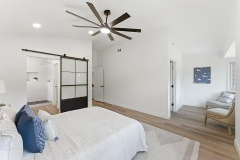 a bedroom with a large bed and a chandelier