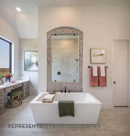 a bathroom with a tub a sink and mirror