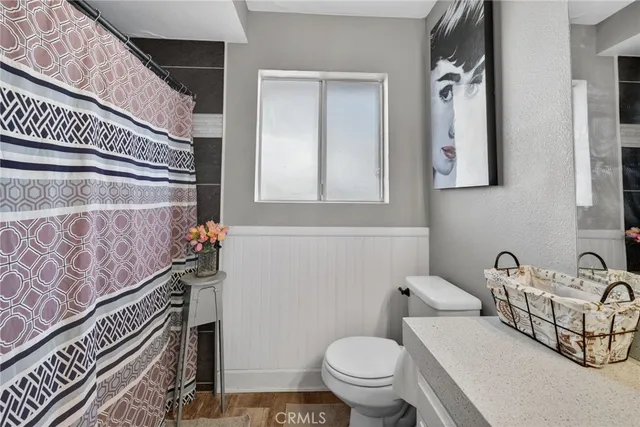 a bathroom with a toilet a sink and mirror