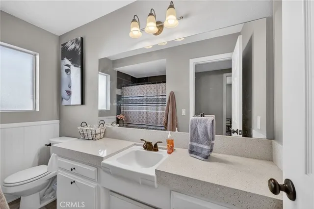 a bathroom with a sink a toilet and a mirror