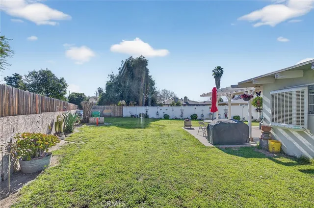 a view of a house with a yard and a large tree