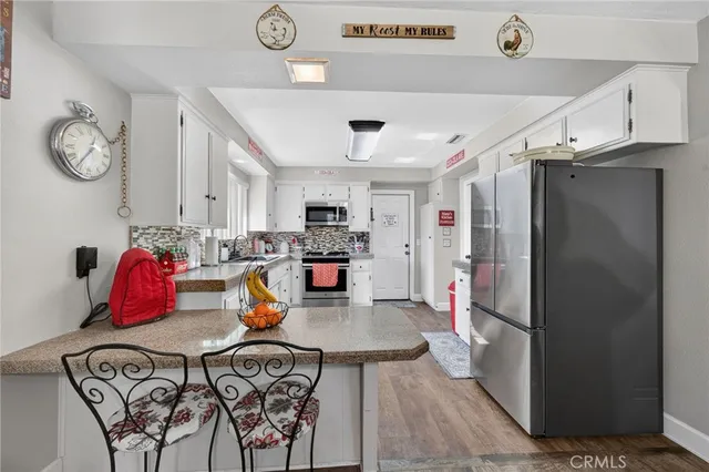 a kitchen with stainless steel appliances granite countertop a refrigerator and microwave
