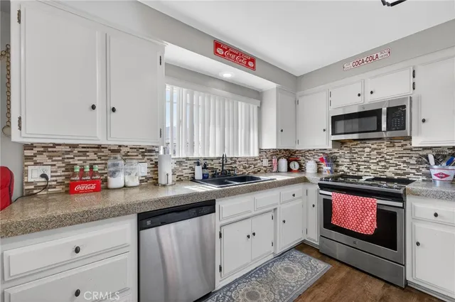 a kitchen with granite countertop a sink stainless steel appliances and cabinets