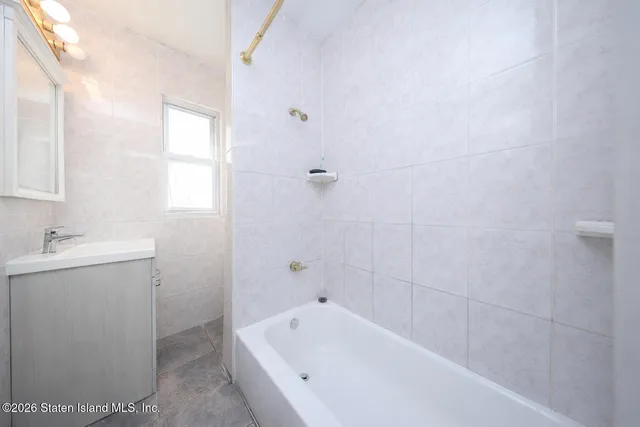 a bathroom with a tub sink and mirror