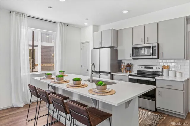 a kitchen with stainless steel appliances granite countertop a table chairs stove refrigerator and cabinets