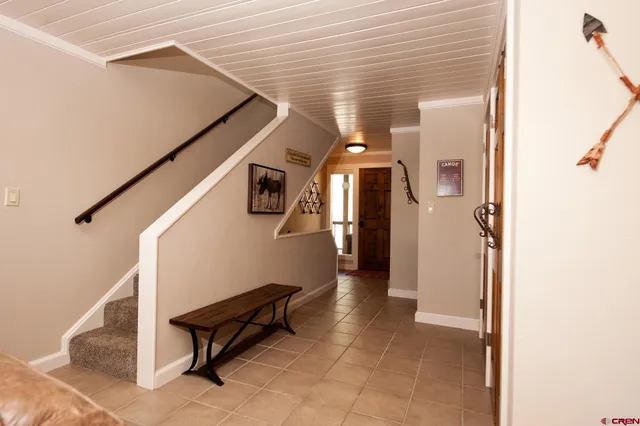 a hallway with bench and a rug