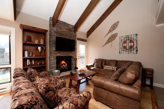 a living room with furniture a flat screen tv and a fireplace