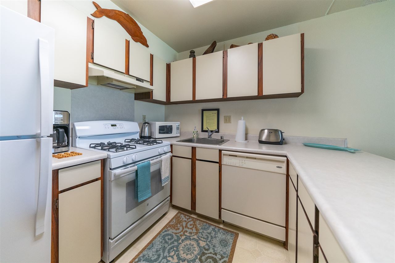 2531 South Kihei Road, Unit DG06 Kihei, HI 96753 - Photo 13 of 16 a kitchen with stainless steel appliances granite countertop a sink and a stove top oven