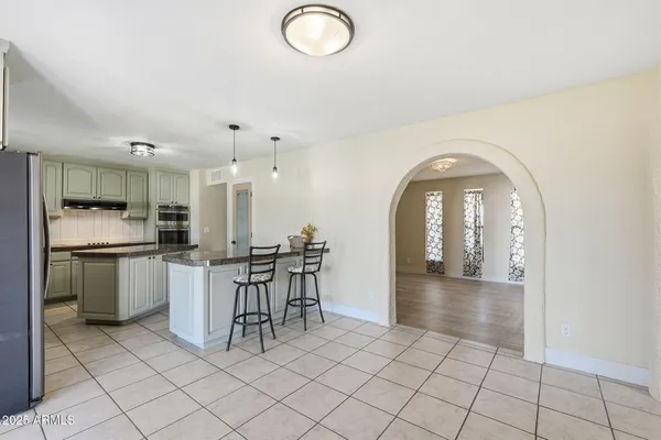 a kitchen with stainless steel appliances granite countertop a sink and a refrigerator