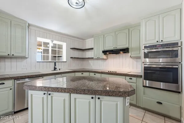 a kitchen with stainless steel appliances granite countertop a sink stove and cabinets