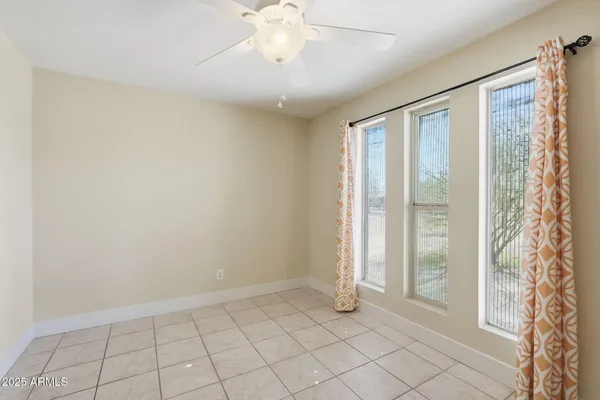 an empty room with closet and a ceiling fan