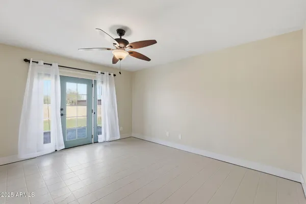 an empty room with closet and a ceiling fan