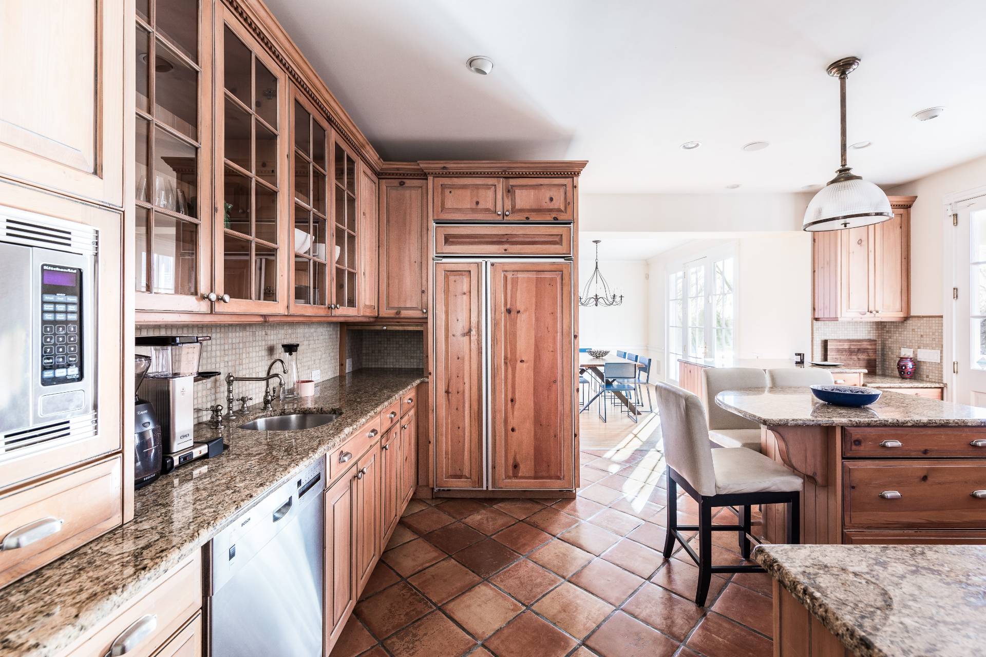5 Mill Path Bridgehampton, NY 11963 - Photo 21 of 30 a kitchen with stainless steel appliances granite countertop a refrigerator a sink dishwasher a dining table and chairs with wooden floor