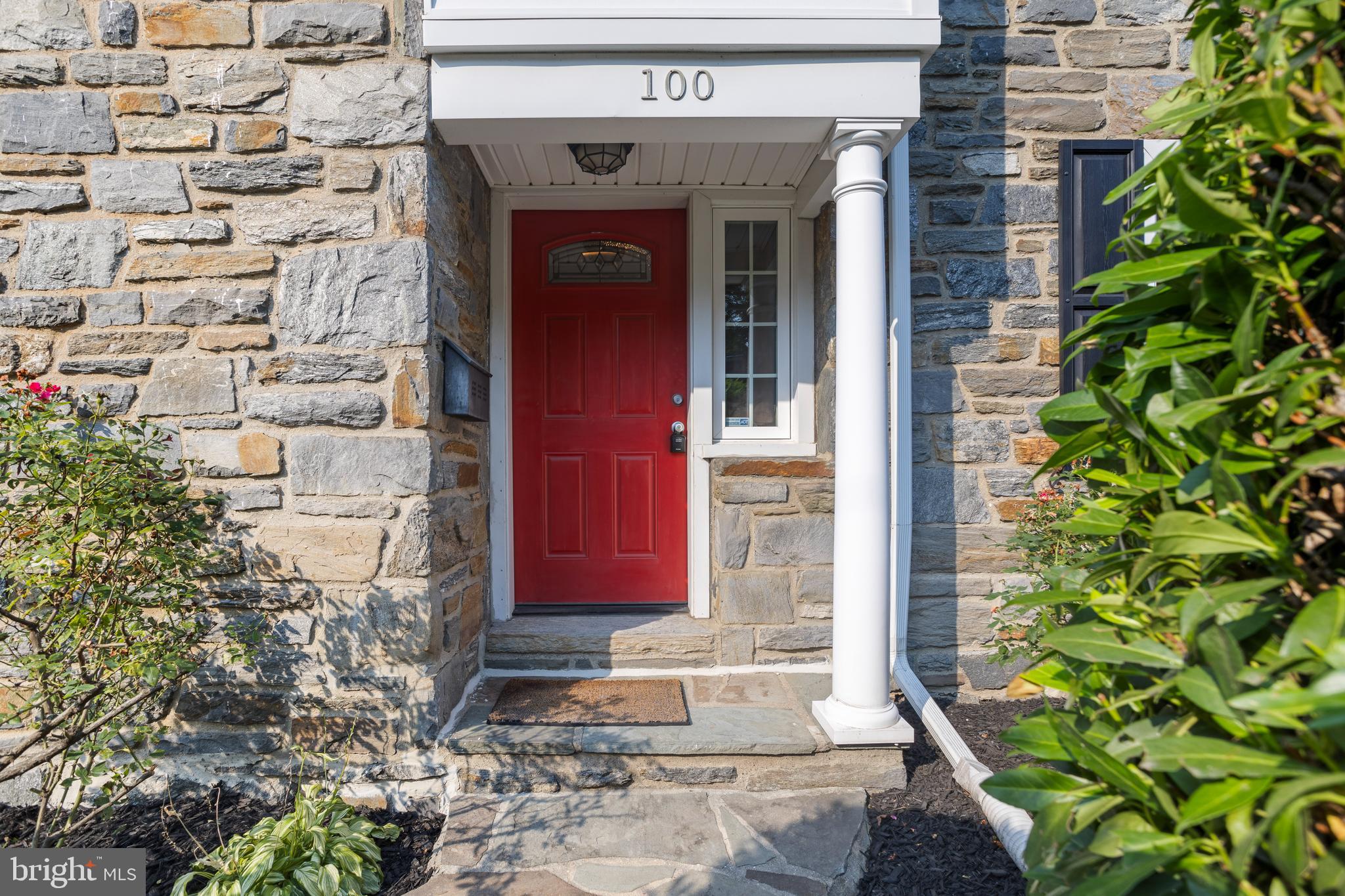 100 Shelburne Road Springfield, PA 19064 - Photo 2 of 31 a view of a brick house with a red door and a plant