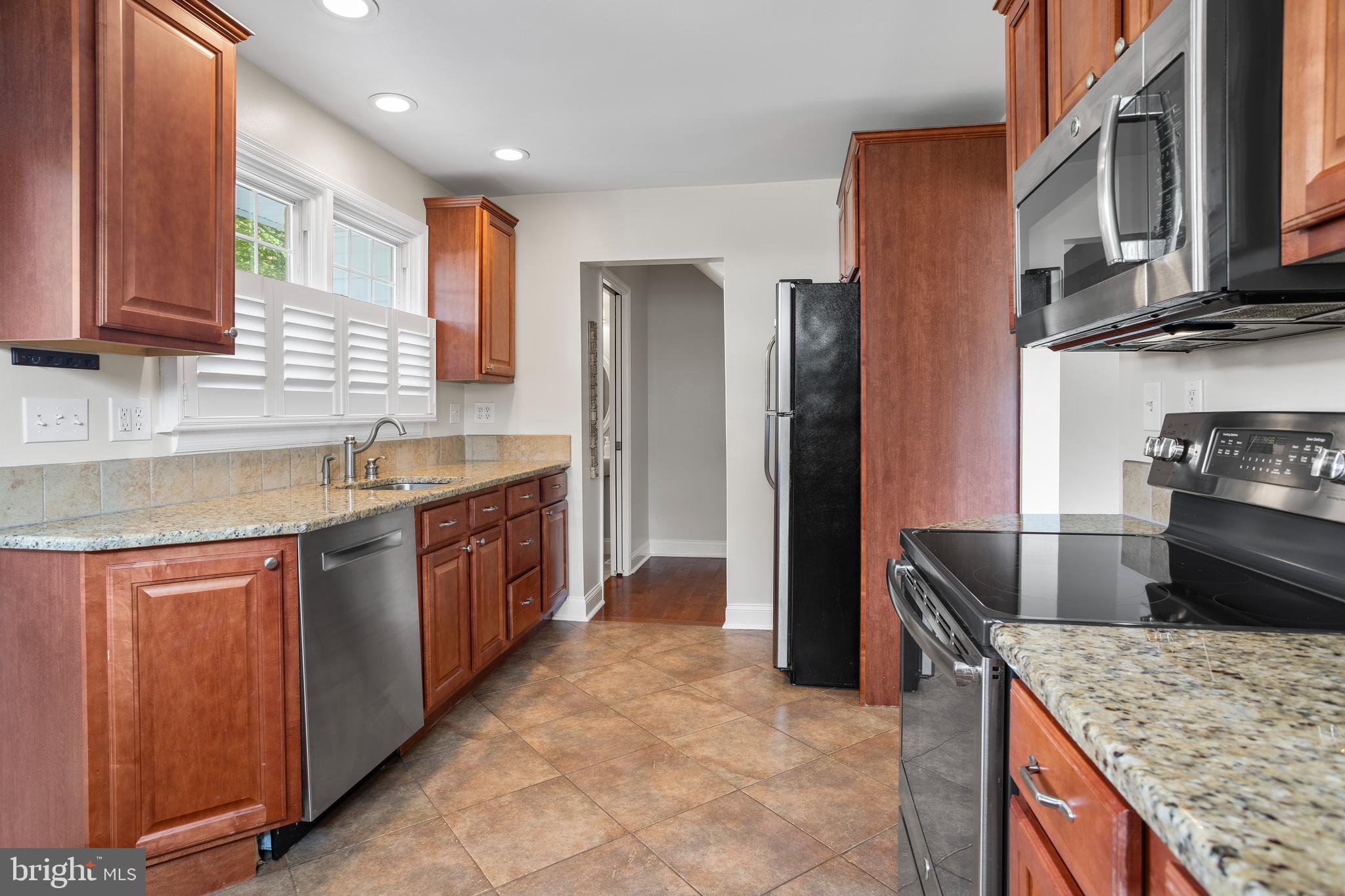 100 Shelburne Road Springfield, PA 19064 - Photo 9 of 31 a kitchen with stainless steel appliances granite countertop a sink stove and refrigerator