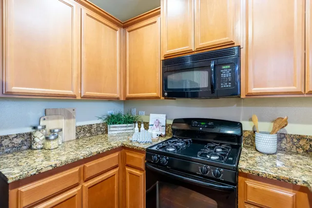 a kitchen with granite countertop wood cabinets and a stove top oven