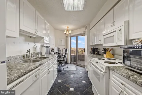 a kitchen with kitchen island granite countertop a sink stove and cabinets