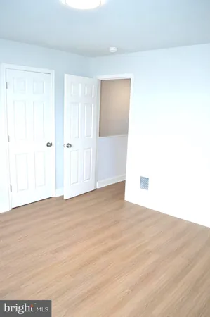 a view of a refrigerator in kitchen and an empty room