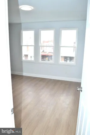 a view of a refrigerator in kitchen and an empty room