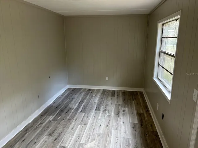 a view of a room with wooden floor and fan